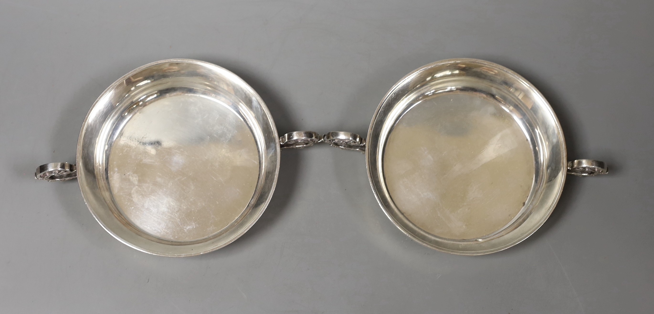 A pair of modern silver two-handled shallow nut dishes, with engraved inscription to the base, Royal Irish Silver Co. Sheffield, 1973, 15.1cm over handles, 193 grams.